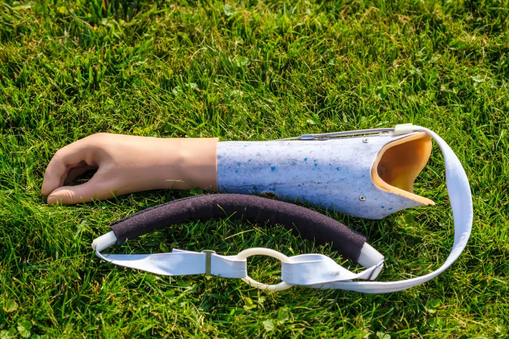 Hilfsmittel. Menschliche Handprothese liegt auf dem Gras